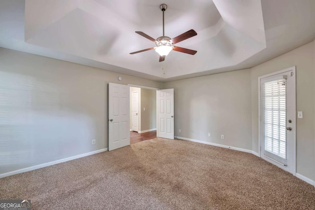 616 Lone Oak Ct, Lithonia, GA 30058 - unfurnished bedroom featuring a tray ceiling, carpet floors, baseboards, and a ceiling fan