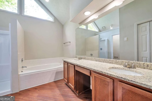616 Lone Oak Ct, Lithonia, GA 30058 - bathroom with lofted ceiling, a bath, wood finished floors, an enclosed shower, and double vanity