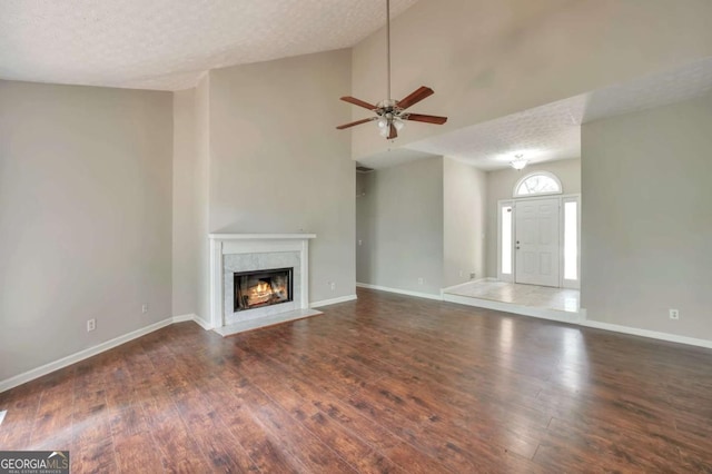 616 Lone Oak Ct, Lithonia, GA 30058 - unfurnished living room with wood finished floors, ceiling fan, a fireplace, a textured ceiling, and baseboards
