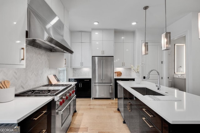 574 Boulevard Pl NE Unit 4, Atlanta, GA 30308 - kitchen with premium appliances, wall chimney exhaust hood, a sink, a kitchen island with sink, and light countertops