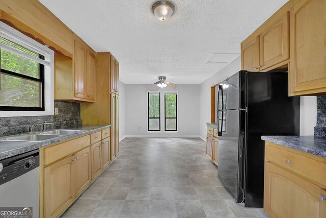 361 Gordon Valley Ln SW, Mableton, GA 30126 - kitchen with stainless steel dishwasher, a sink, freestanding refrigerator, a textured ceiling, and backsplash