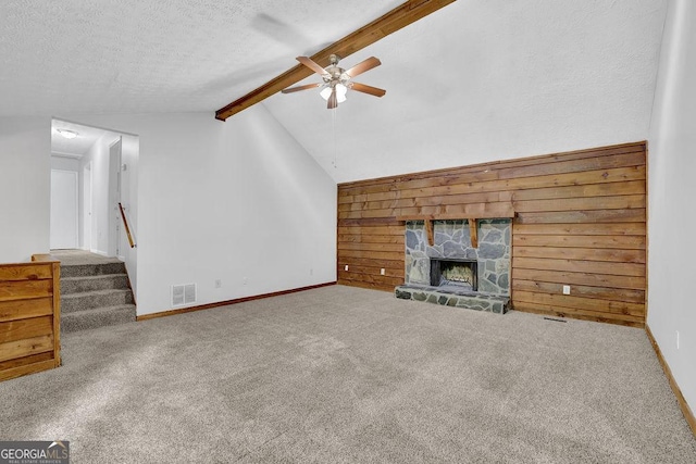 361 Gordon Valley Ln SW, Mableton, GA 30126 - unfurnished living room with ceiling fan, wood walls, carpet floors, a stone fireplace, and a textured ceiling