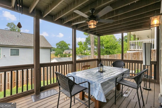 wooden deck with outdoor dining area, a ceiling fan, and fence