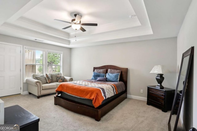 carpeted bedroom with a tray ceiling, baseboards, and a ceiling fan