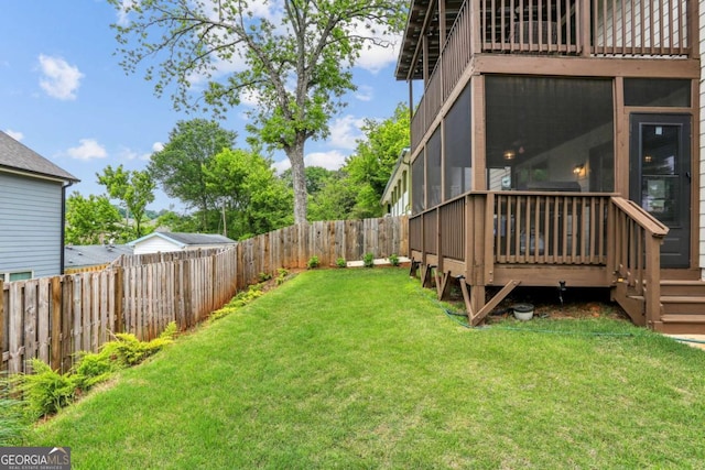 view of yard featuring a sunroom and a deck