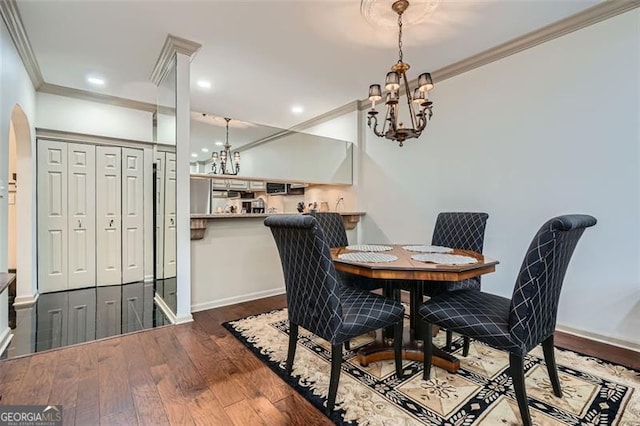 2499 Peachtree Rd Unit 108, Atlanta, GA 30305 - dining space featuring a chandelier, crown molding, dark wood-style flooring, arched walkways, and baseboards