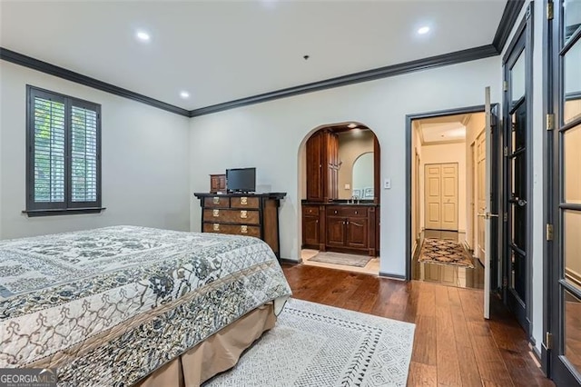 2499 Peachtree Rd Unit 108, Atlanta, GA 30305 - bedroom featuring dark wood-type flooring, crown molding, arched walkways, recessed lighting, and ensuite bathroom