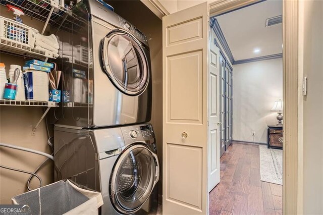 2499 Peachtree Rd Unit 108, Atlanta, GA 30305 - laundry area featuring stacked washer and clothes dryer, wood-type flooring, baseboards, and crown molding