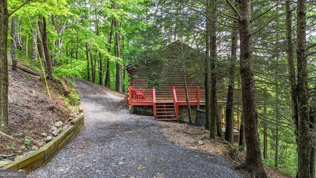 1157 Laurel Creek Rd, Blue Ridge, GA 30513 - view of front of house with log exterior, a wooden deck, and a wooded view