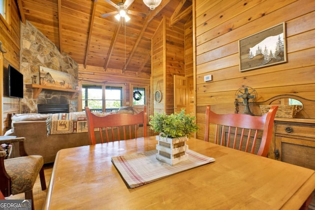 1157 Laurel Creek Rd, Blue Ridge, GA 30513 - dining room featuring wood ceiling, wooden walls, ceiling fan, a stone fireplace, and beam ceiling