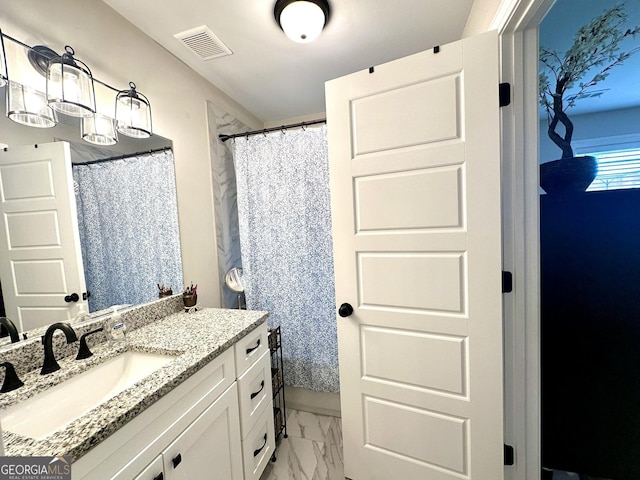 full bath featuring marble look tiles, vanity, and a shower with curtain