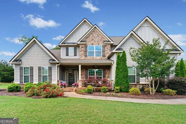 161 Archstone Sq, Mcdonough, GA 30253 - craftsman-style home featuring board and batten siding, covered porch, a front yard, and stone siding