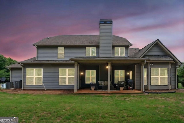 161 Archstone Sq, Mcdonough, GA 30253 - back of house at dusk featuring a chimney, a patio, outdoor lounge area, and central AC