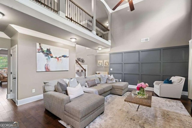 161 Archstone Sq, Mcdonough, GA 30253 - living room featuring a decorative wall, ceiling fan, a towering ceiling, dark wood-type flooring, and baseboards
