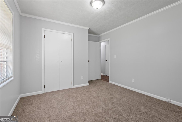 684 Hog Liver Rd, Carrollton, GA 30117 - unfurnished bedroom featuring carpet, baseboards, crown molding, a closet, and a textured ceiling