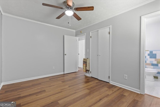 684 Hog Liver Rd, Carrollton, GA 30117 - unfurnished bedroom featuring wood finished floors, ornamental molding, connected bathroom, a ceiling fan, and baseboards