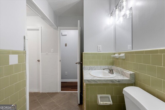 684 Hog Liver Rd, Carrollton, GA 30117 - half bathroom featuring tile walls, a sink, tile patterned floors, wainscoting, and toilet