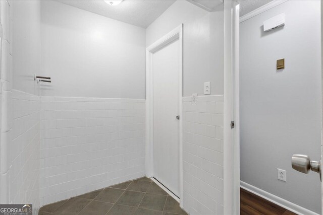 684 Hog Liver Rd, Carrollton, GA 30117 - bathroom with a textured ceiling, a wainscoted wall, and tile walls