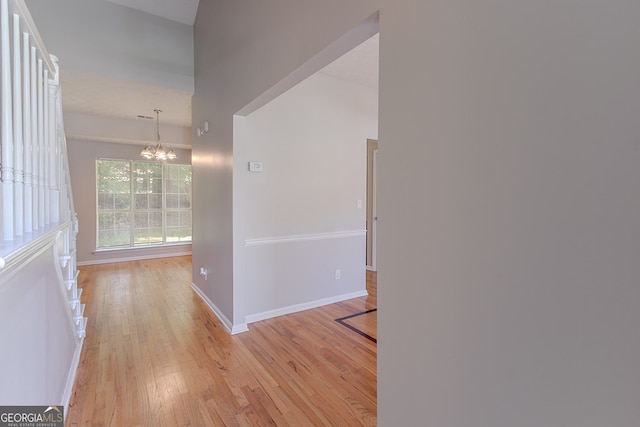 12241 Cypress Way, Fayetteville, GA 30215 - corridor with light wood-style flooring, a chandelier, and baseboards