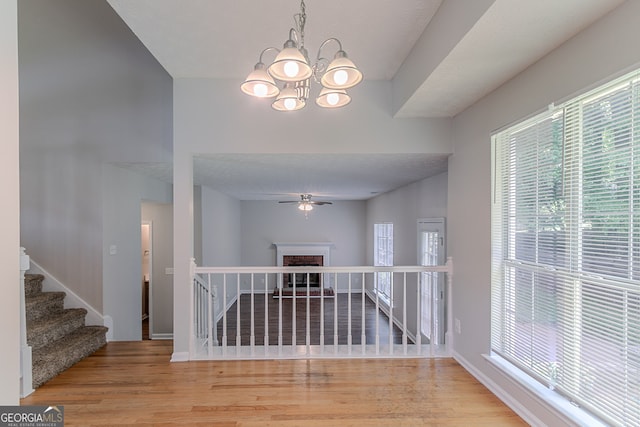 12241 Cypress Way, Fayetteville, GA 30215 - empty room with wood finished floors, a ceiling fan, a chandelier, and plenty of natural light
