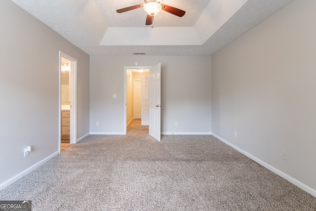 12241 Cypress Way, Fayetteville, GA 30215 - unfurnished bedroom with a tray ceiling, light colored carpet, baseboards, ensuite bathroom, and ceiling fan