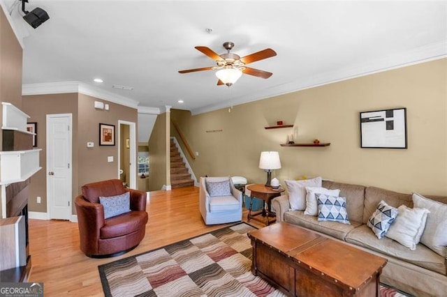 living area with crown molding, ceiling fan, light wood finished floors, recessed lighting, and stairs