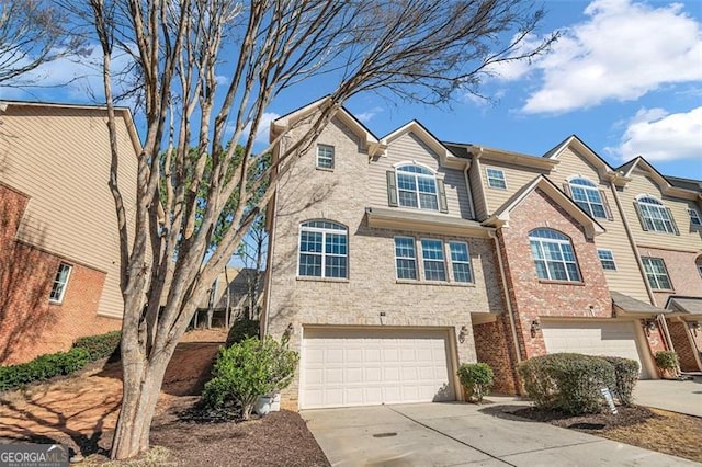 multi unit property featuring driveway, a garage, and brick siding