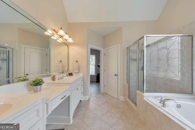 full bath with a stall shower, double vanity, a bath, tile patterned floors, and vaulted ceiling