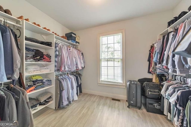 walk in closet with wood finished floors