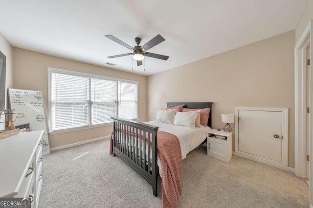 bedroom featuring light carpet, ceiling fan, and baseboards