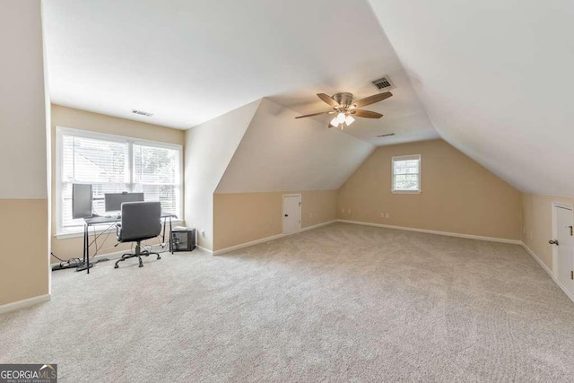 unfurnished office featuring carpet floors, baseboards, ceiling fan, and vaulted ceiling