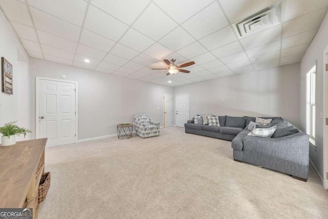 living room with a paneled ceiling, carpet, ceiling fan, and baseboards