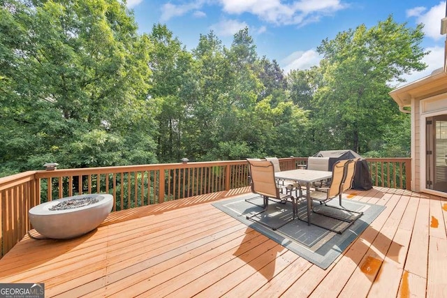 wooden deck with outdoor dining space and a grill