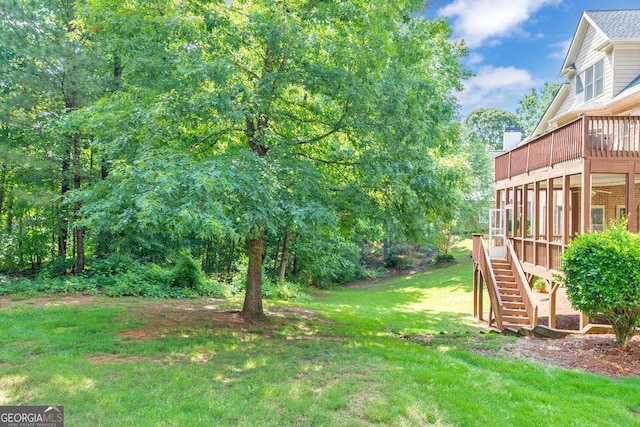 view of green lawn with stairway and a deck
