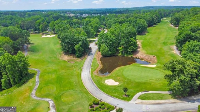 aerial view of a nearby body of water, a golf course, and a forest