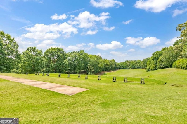 view of home's community with a yard, view of scattered trees, and view of golf course