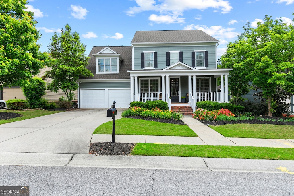 6069 Queens River Dr, Mableton, GA 30126 - traditional home featuring a porch, driveway, an attached garage, a front yard, and a shingled roof