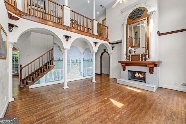 11569 Finley Rd, Johns Creek, GA 30024 - entryway featuring a towering ceiling, a glass covered fireplace, ceiling fan, wood finished floors, and baseboards