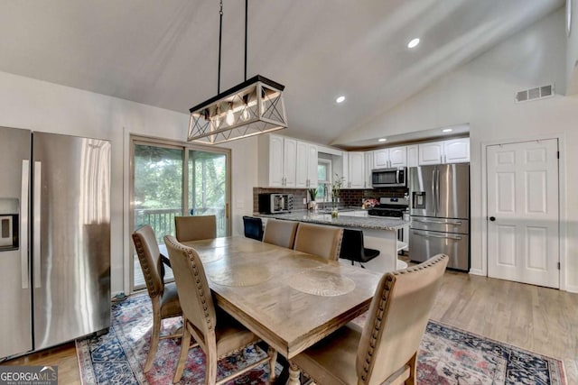 1358 Millstream Trl, Lawrenceville, GA 30044 - dining area featuring lofted ceiling, healthy amount of natural light, light wood-style flooring, and recessed lighting