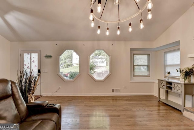 1358 Millstream Trl, Lawrenceville, GA 30044 - living room with wood finished floors, vaulted ceiling, baseboards, and a chandelier