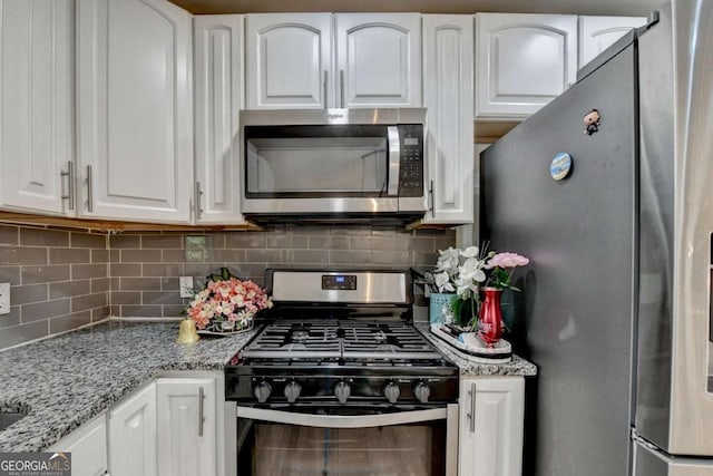 1358 Millstream Trl, Lawrenceville, GA 30044 - kitchen with stainless steel appliances, white cabinets, backsplash, and light stone counters