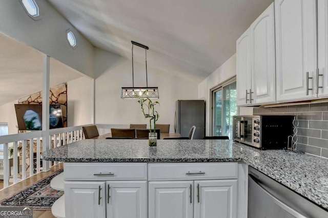 1358 Millstream Trl, Lawrenceville, GA 30044 - kitchen with stainless steel appliances, lofted ceiling, decorative backsplash, a peninsula, and white cabinets