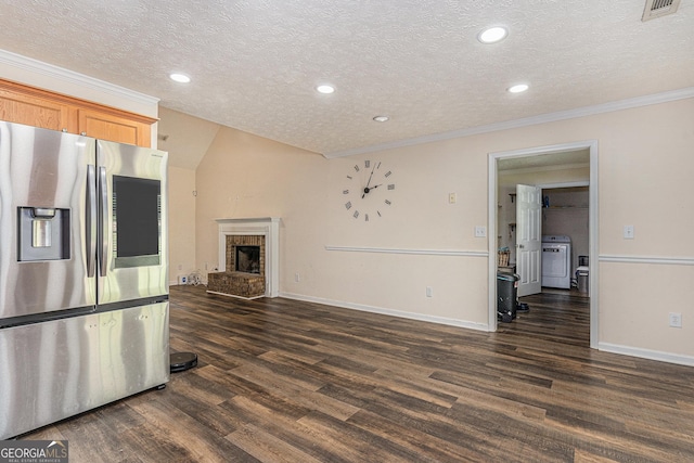 220 Windpher Rdg, Hampton, GA 30228 - unfurnished living room with washer / dryer, dark wood-style floors, a textured ceiling, ornamental molding, and a fireplace