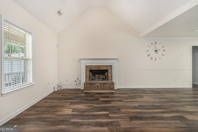220 Windpher Rdg, Hampton, GA 30228 - unfurnished living room featuring vaulted ceiling, wood finished floors, a brick fireplace, and baseboards