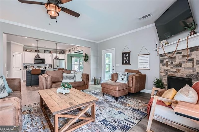 837 Brown Thrasher Way, Bremen, GA 30110 - living room with light wood-type flooring, ceiling fan, a fireplace, and ornamental molding