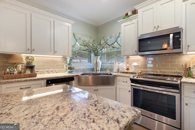 156 Hannah Dr, Jesup, GA 31546 - kitchen featuring stainless steel appliances, white cabinets, tasteful backsplash, crown molding, and light stone counters