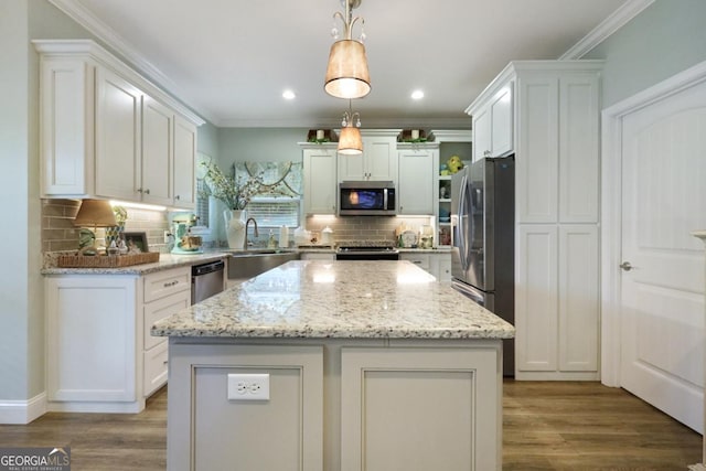 156 Hannah Dr, Jesup, GA 31546 - kitchen featuring stainless steel appliances, white cabinetry, decorative backsplash, a center island, and wood finished floors