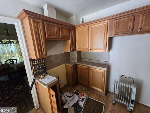 25 Candler Rd SE, Atlanta, GA 30317 - kitchen with light wood finished floors, brown cabinets, and a chandelier