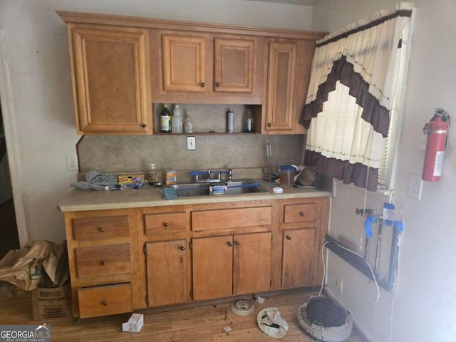 25 Candler Rd SE, Atlanta, GA 30317 - kitchen featuring light countertops, a sink, backsplash, and brown cabinets