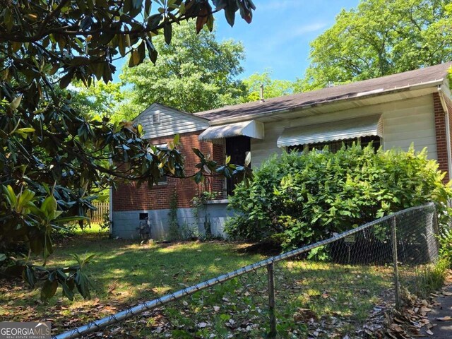 25 Candler Rd SE, Atlanta, GA 30317 - view of side of property featuring fence, brick siding, and roof with shingles